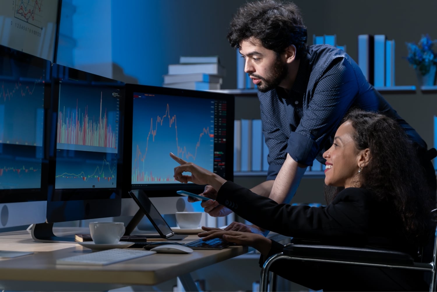 Two traders analysing changing market conditions on a multi-monitor trading desk